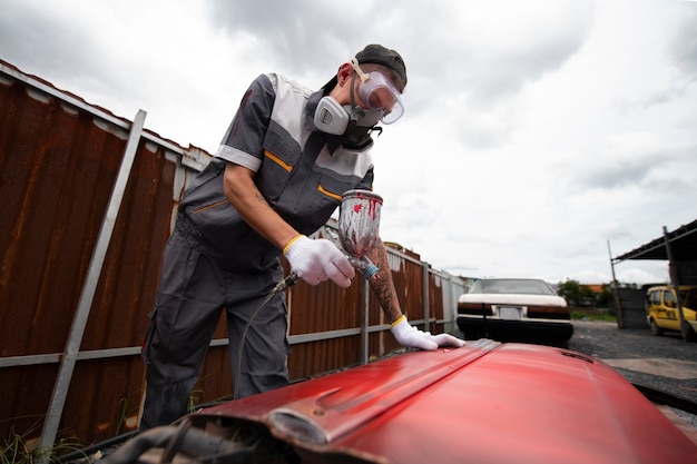 Foto gratuita hombre pintando puerta de coche plano medio