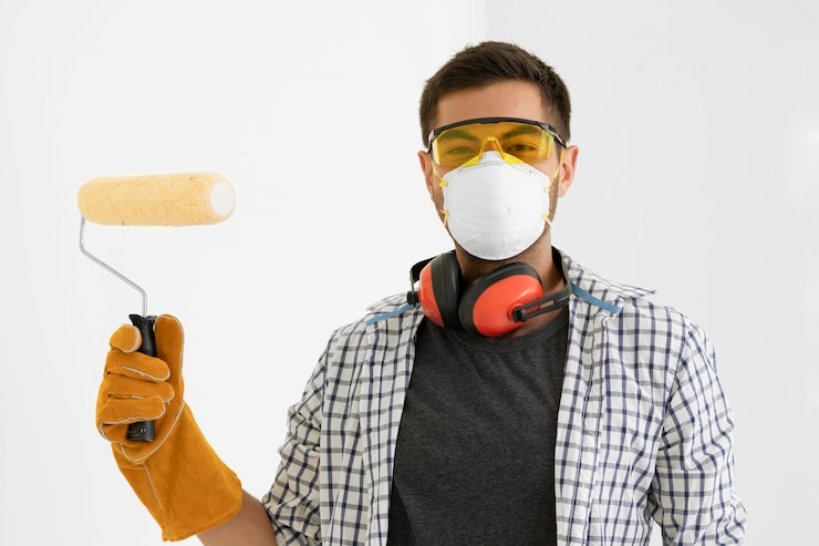 Foto gratuito hombre con pintura de equipos de protección de seguridad