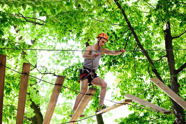 Hombre pisa en los bloques de madera que cuelgan en el aire