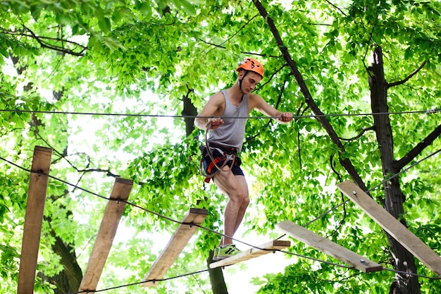 Hombre pisa en las tablas de madera que cuelgan en el aire