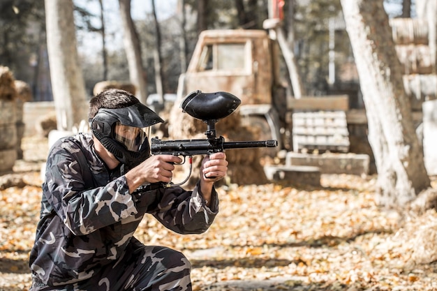 Un hombre con una pistola jugando paintball.