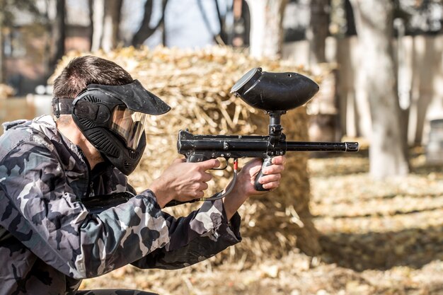 Un hombre con una pistola jugando paintball.