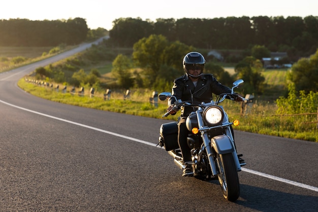 Hombre de plano completo conduciendo una moto.