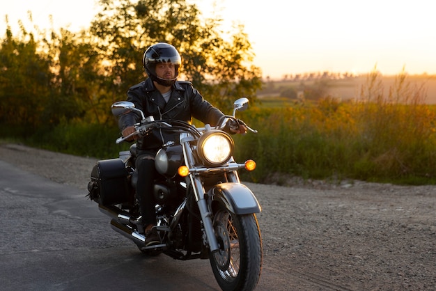 Foto gratuita hombre de plano completo conduciendo una moto.