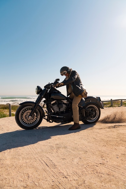 Foto gratuita hombre de plano completo conduciendo una moto.