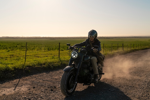 Hombre de plano completo conduciendo una moto.