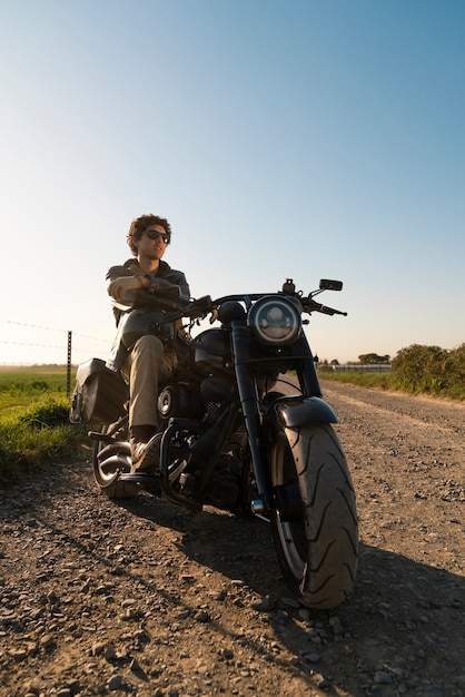 Foto gratuita hombre de plano completo conduciendo una moto.