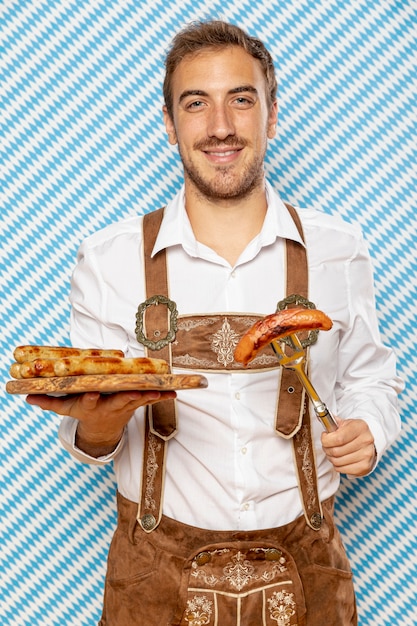 Foto gratuita hombre con plato de madera de salchichas alemanas