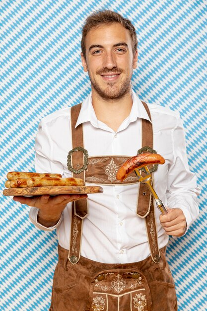 Hombre con plato de madera de salchichas alemanas