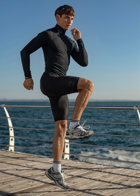 Hombre en la playa entrenando en ropa deportiva