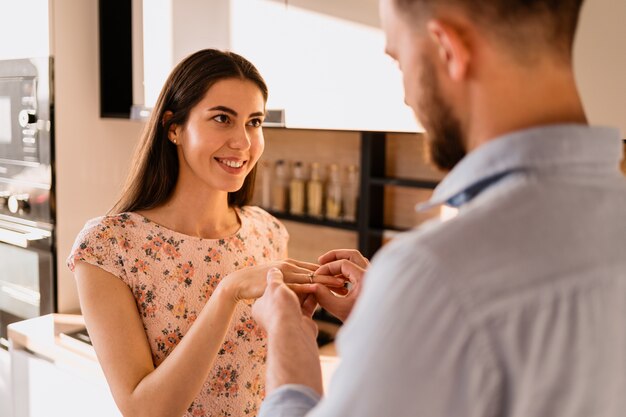 El hombre pone el anillo en el dedo de su novia