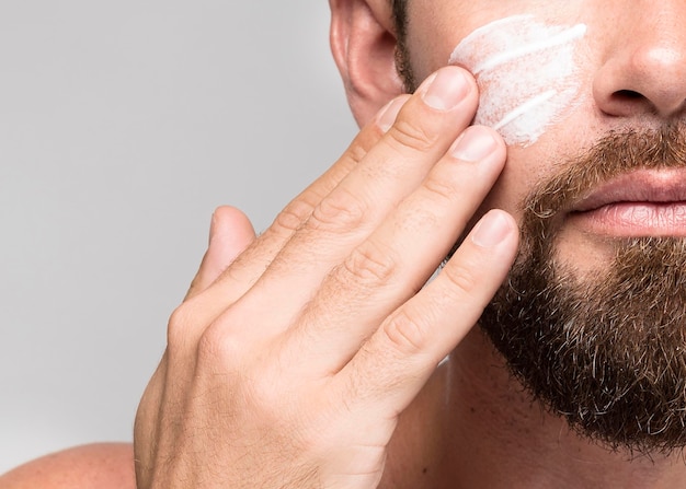 Hombre, poniendo, crema facial, primer plano