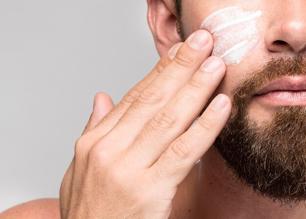 Hombre, poniendo, crema facial, primer plano