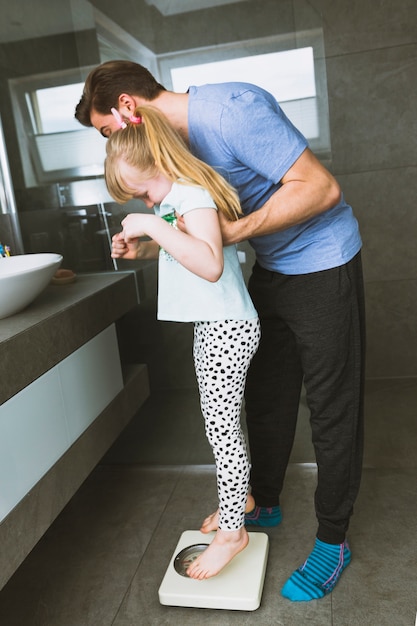 Foto gratuita hombre poniendo hija en escalas