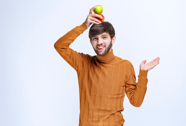 Hombre poniendo manzana verde sobre su cabeza.