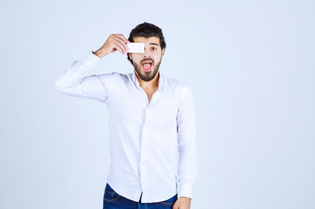 Hombre poniendo su tarjeta en el ojo