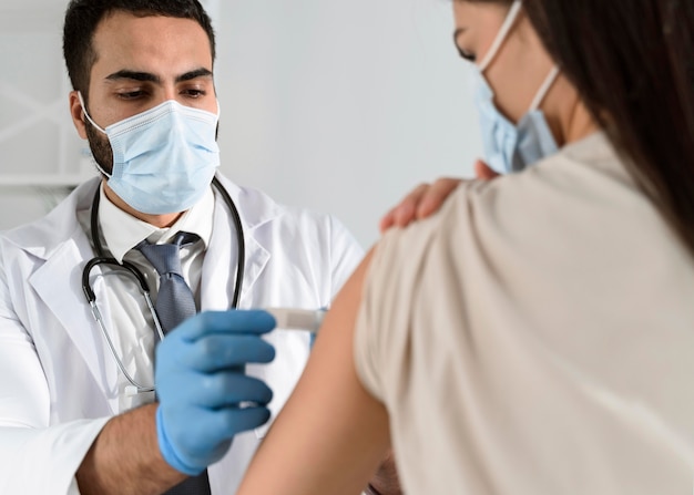 Foto gratuita hombre poniendo un vendaje en el brazo de un paciente