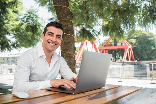 Foto gratuita hombre con portátil al aire libre