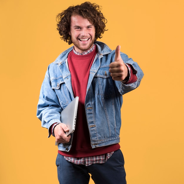 Hombre con portátil haciendo gesto de pulgar arriba