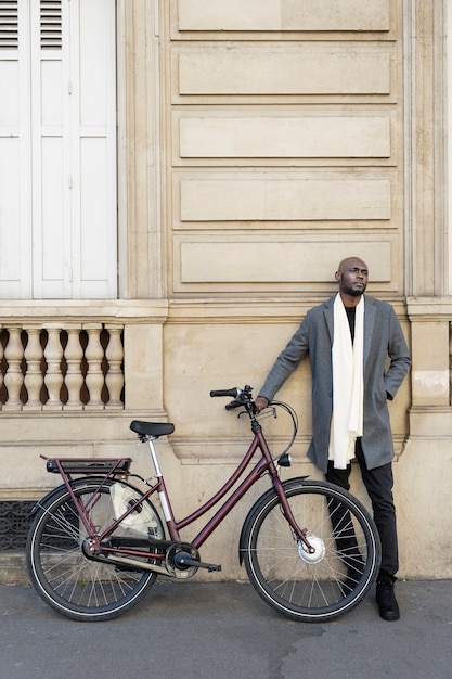 Foto gratuita hombre posando con una bicicleta en la ciudad de francia
