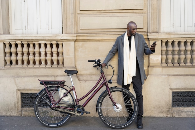 Foto gratuita hombre posando con una bicicleta en la ciudad de francia