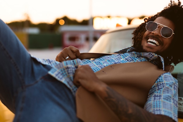 Foto gratuita hombre posando en estilo retro al aire libre con gafas de sol