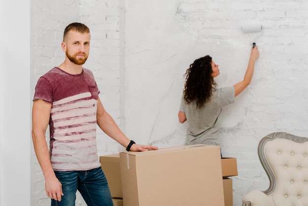 Hombre posando junto a la pared de pintura de la mujer