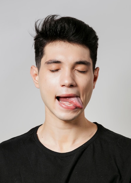 Hombre posando con los ojos cerrados y la lengua fuera