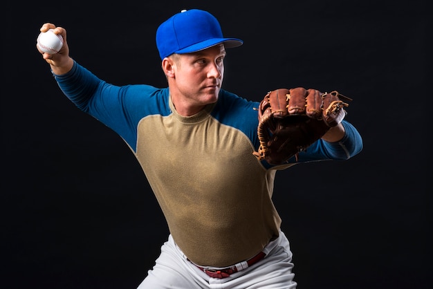 Foto gratuita hombre posando con pelota y guante de béisbol