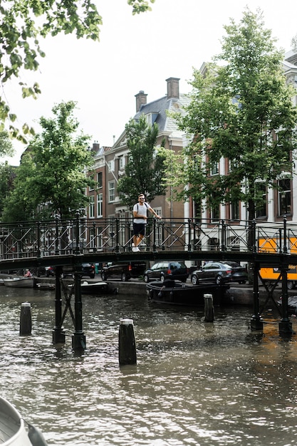 Hombre posando en el puente de amsterdam.