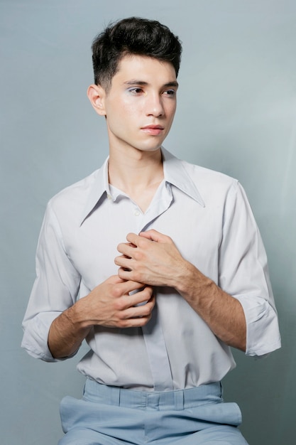 Hombre posando y sosteniendo la camisa