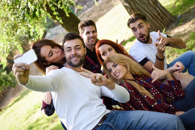 Hombre posando con sus amigos para una autofoto