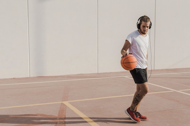 Foto gratuita hombre practicando baloncesto en la cancha