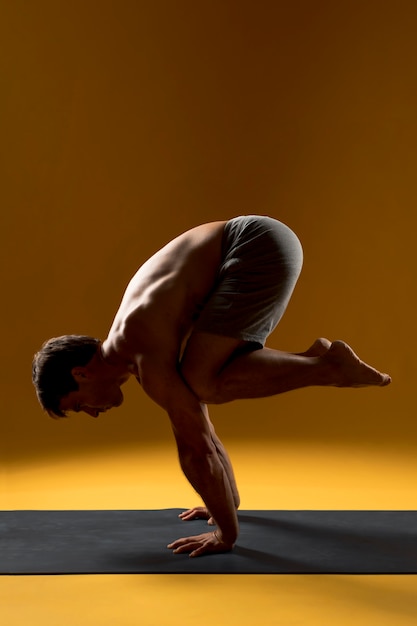 Foto gratuita hombre practicando equilibrio yoga pose
