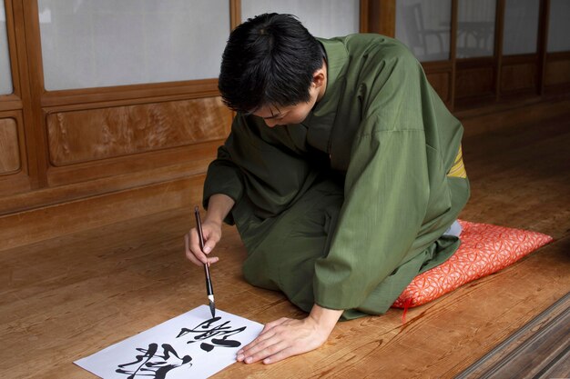 Hombre practicando la escritura japonesa