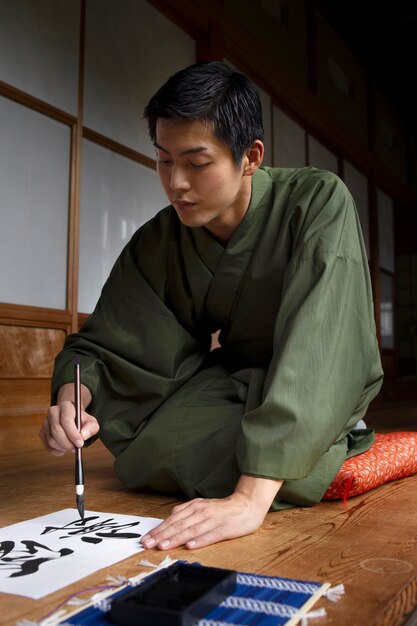 Hombre practicando la escritura japonesa