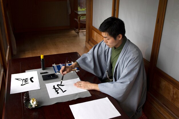 Hombre practicando la escritura japonesa