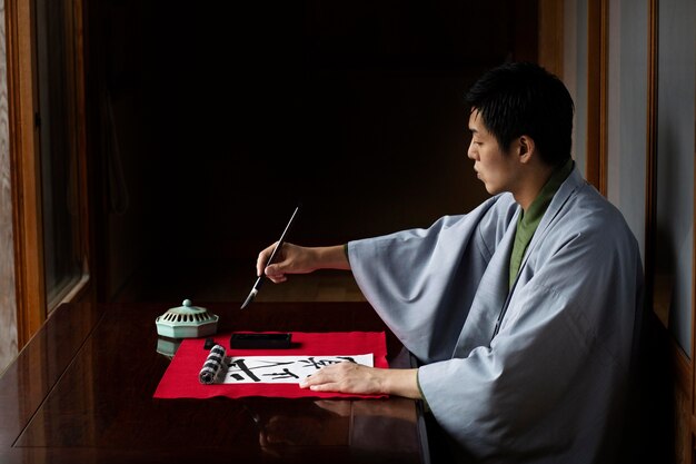 Hombre practicando la escritura japonesa