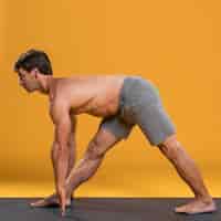Foto gratuita hombre practicando yoga en colchoneta