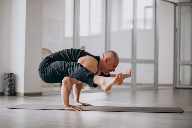 Hombre practicando yoga en el gimnasio