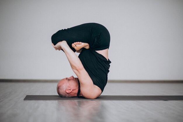 Hombre practicando yoga en el gimnasio