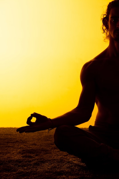 Hombre practicando yoga en la luz del atardecer