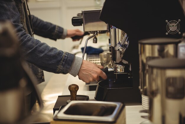 Hombre preparando café en la cafetería.