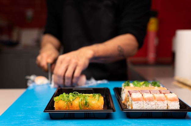 Hombre preparando un pedido de sushi para llevar