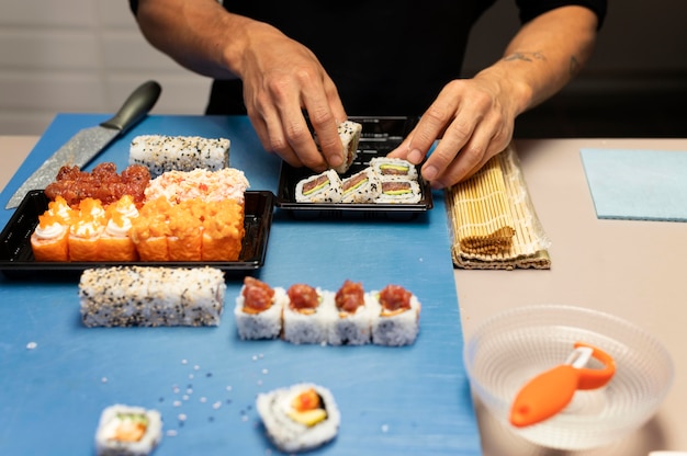 Hombre preparando un pedido de sushi para llevar