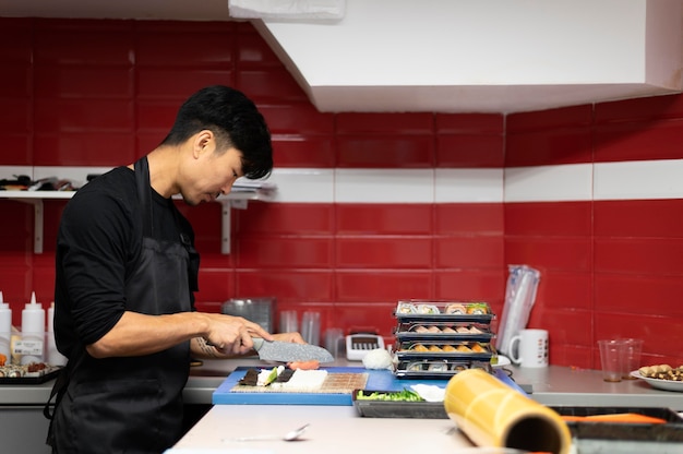 Foto gratuita hombre preparando un pedido de sushi para llevar