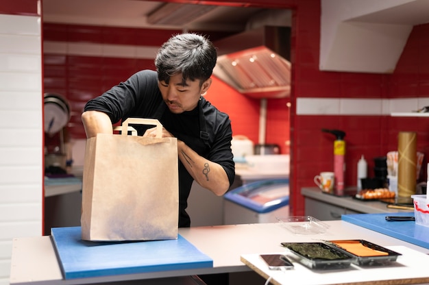 Hombre preparando un pedido de sushi para llevar