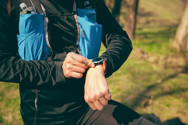 Hombre preparando tu correr en un parque o bosque contra árboles