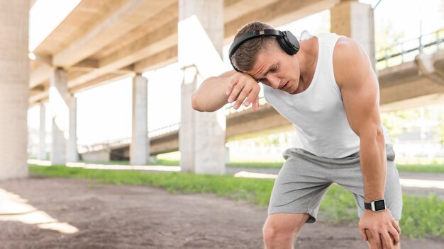 Hombre preparándose para entrenar afuera con espacio de copia