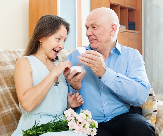 hombre presentando mujer sorprendida joya